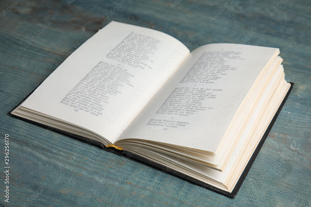 Open book on light blue wooden table