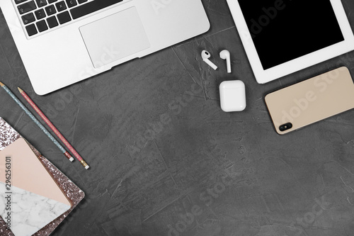 Flat lay composition with phone and tablet on grey stone table, space for text. Designer's workplace