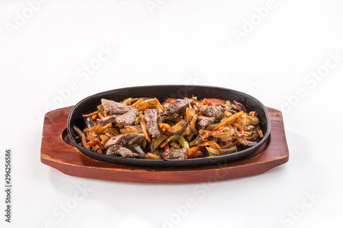 Beef fajitas with colorful vegetables in pan isolated on white background