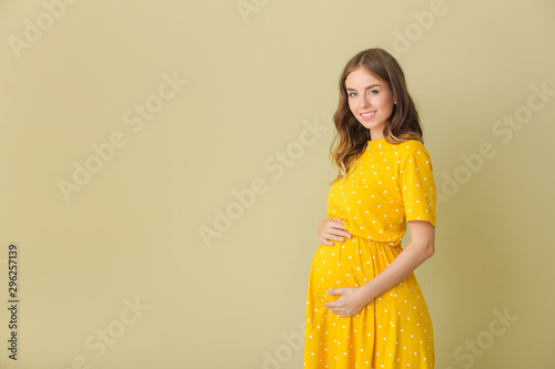 Beautiful pregnant woman on color background photo