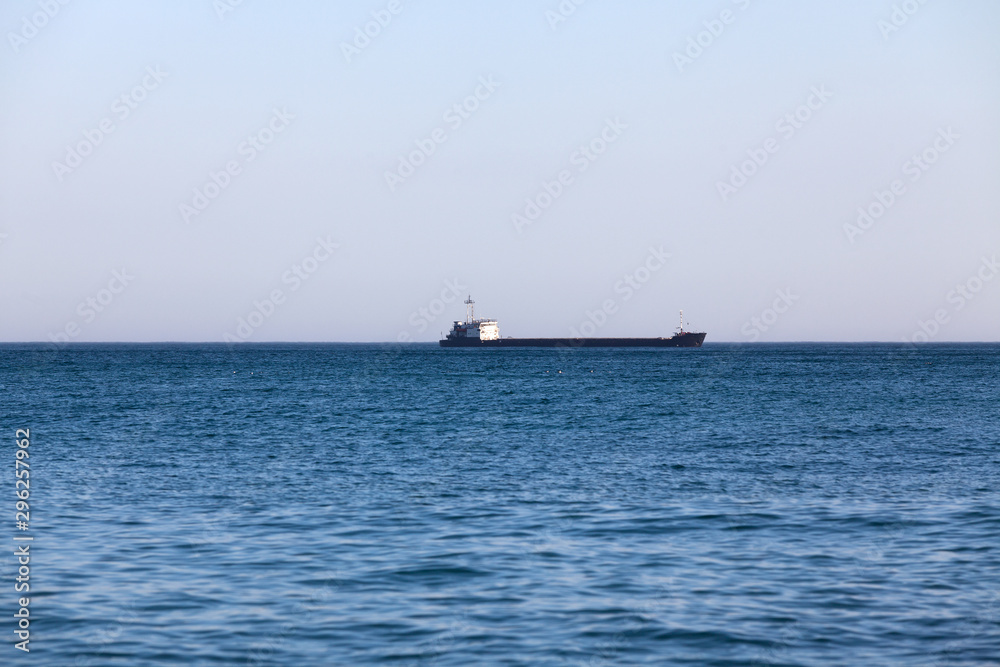 Black Sea. Dry cargo ship on the horizon. The weather is clear. The sea is blue.