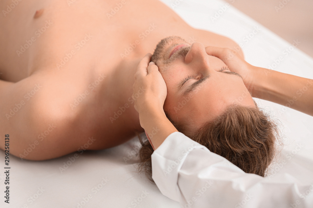 Young man receiving facial massage in spa salon Young man receiving facial massage in spa salon