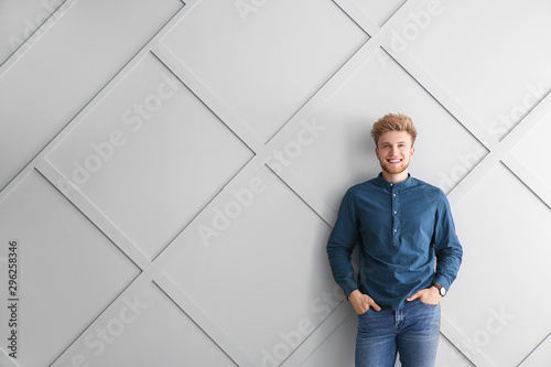 Portrait of young man on grey background © Pixel-Shot