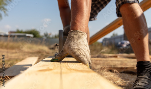 A worker cuts a wooden board at a construction site