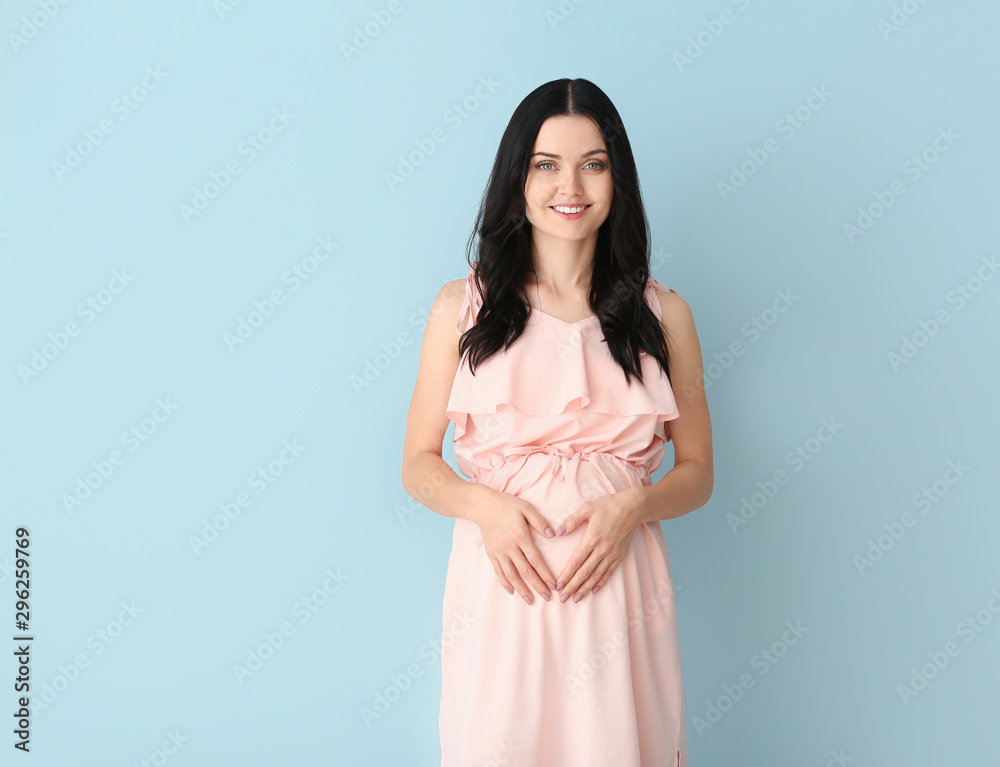 Beautiful young pregnant woman on color background Beautiful young pregnant woman on color background