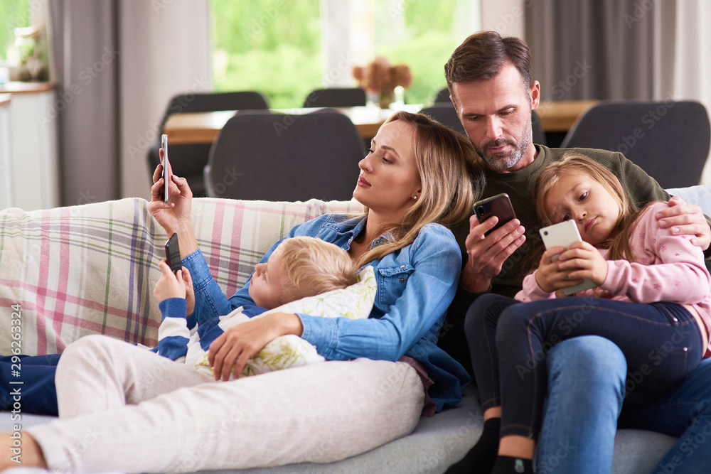 Parents and children using mobile phone in living room Parents and children using mobile phone in living room