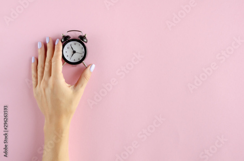 Fototapeta Naklejka Na Ścianę i Meble -  Hand with analog alarm clock composition on pink background.