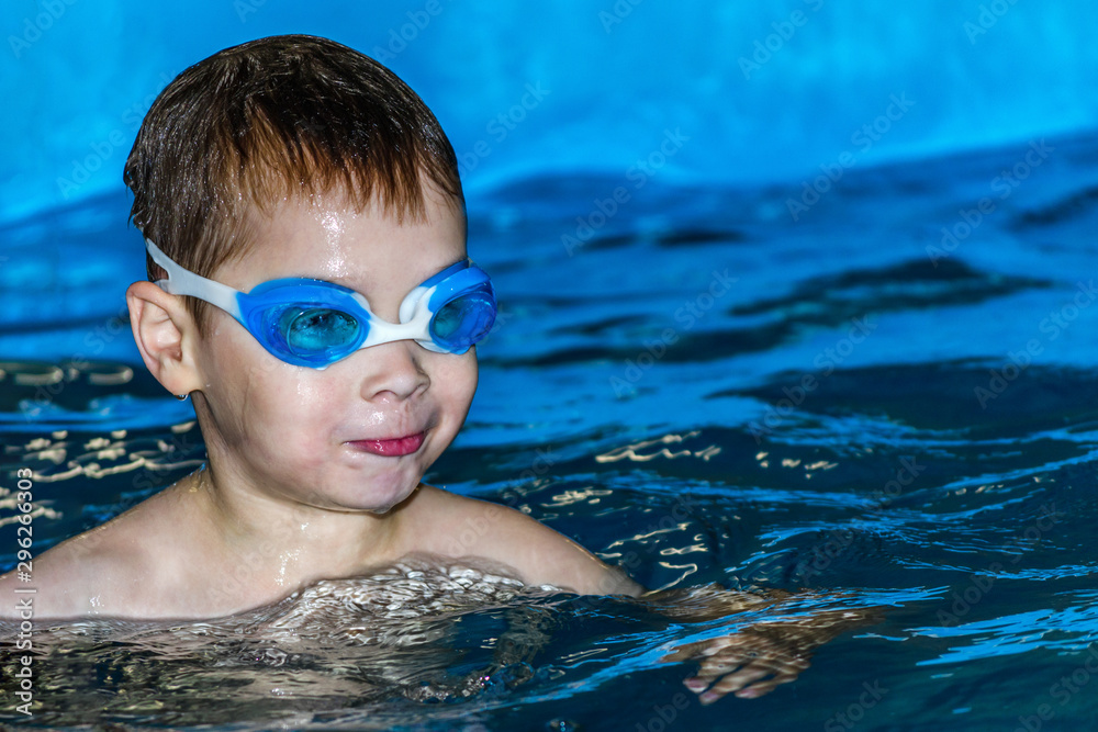 Naklejka premium boy in swimming pool wearing swimming goggles