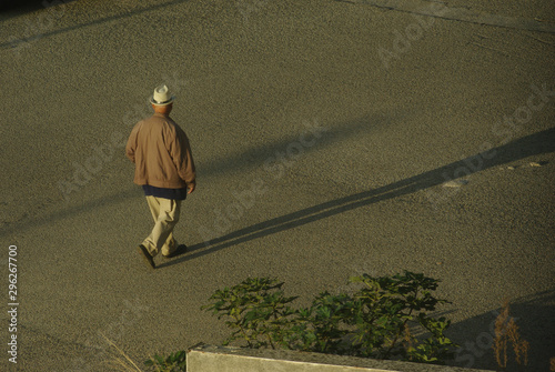 Man in light hat walking down the street