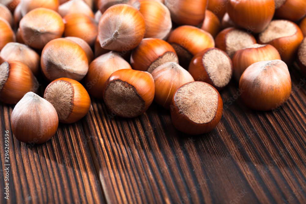 close up of hazelnuts on wooden table .