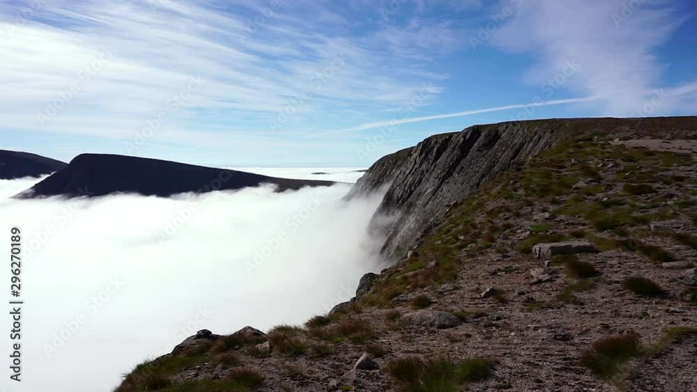 Huge cloud layer forming in the Cairngorms with the Munros mountain Cairn Toul, Sgor an Lochain Uaine and Ben Macdui peaking through at blue sky in the Cairngorm Mountains in the Scottish Highlands. Huge cloud layer forming in the Cairngorms with the Munros mountain Cairn Toul, Sgor an Lochain Uaine and Ben Macdui peaking through at blue sky in the Cairngorm Mountains in the Scottish Highlands.