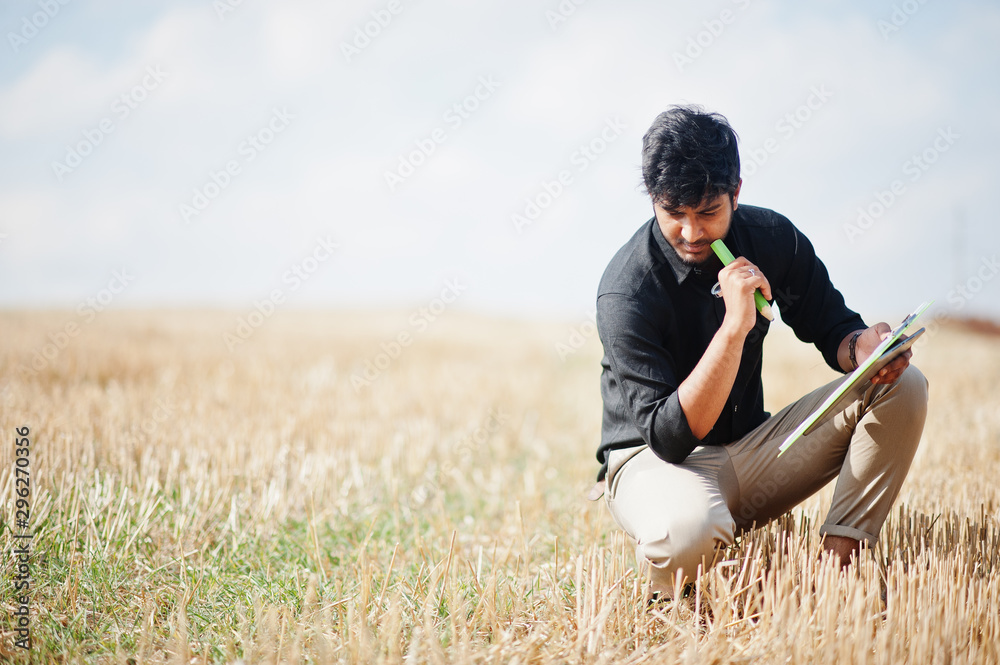 South asian agronomist farmer inspecting wheat field farm. Agriculture production concept. South asian agronomist farmer inspecting wheat field farm. Agriculture production concept.