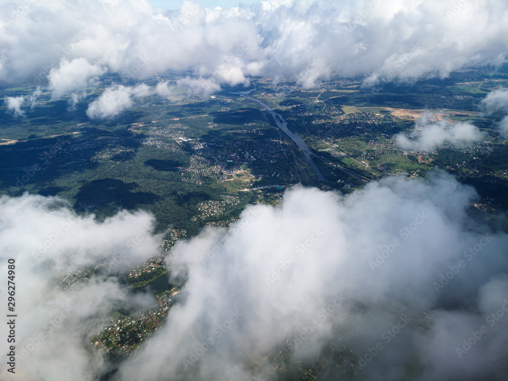 Clouds above the ground view from an airplane as a background