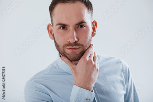 Close up photo. Man in official clothes stands against white background in the studio