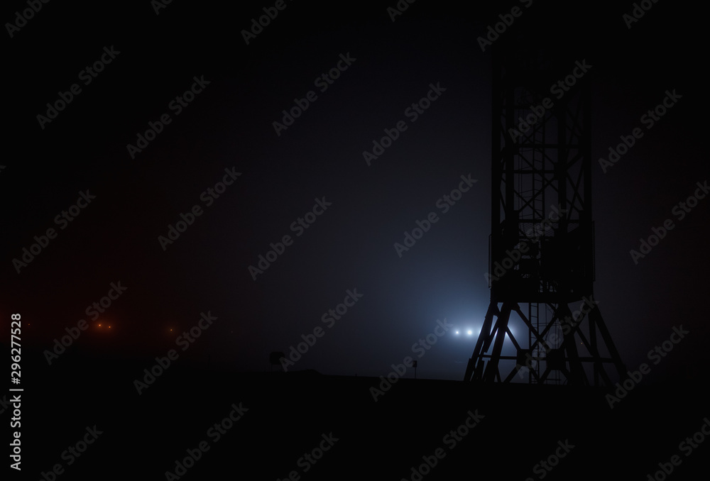 Stadium lights glow in the fog. Small depth of field