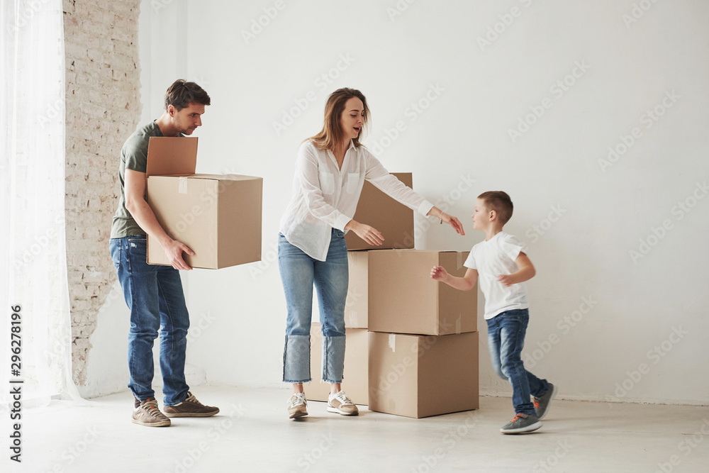 Running kid. Family have removal into new house. Unpacking moving boxes