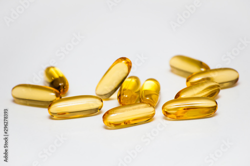 capsules filled with omega 3 fish oil fatty acids lay in a heap on a light gray background, concept of health care and cardiovascular system