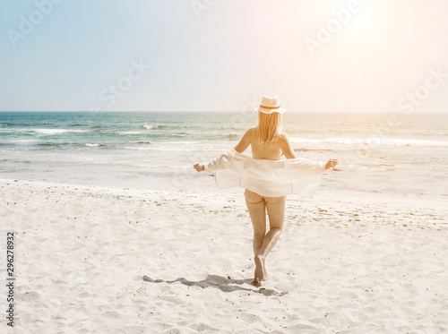 Happy traveller woman in white enjoys her tropical beach vacatio photo