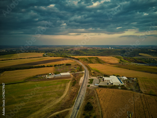 Aerial view of highway with forest and fields at sunset. Autumn landscape.