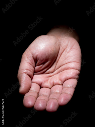 Close up photo of a brown mans hand gesturing for help with some food or loose change © Vineeth