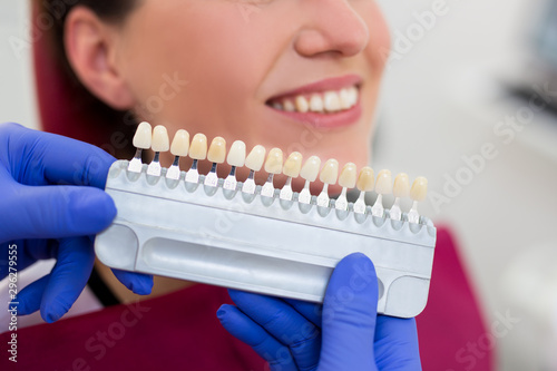 dentist matching teeth color in dental clinic