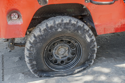 car wheel flat tire on the road, Flatten punctured auto wheel