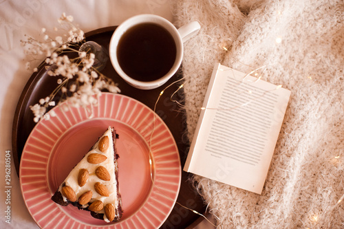 Good morning with hot black tea and chocolate cake with oprn book on knitted cloth close up. Top view. Breakfast time. photo