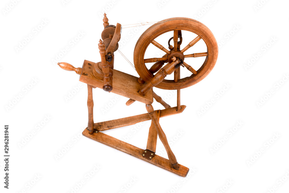 Old spinning wheel isolated on a white background. A closeup of a very old wheel and spokes of a hand crafted spinning wheel made from natural wood. Historical working tool. Isolated, white background