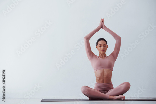 Fototapeta Naklejka Na Ścianę i Meble -  Lotus pose. Caucasian pretty woman doing exercises against white background in the studio