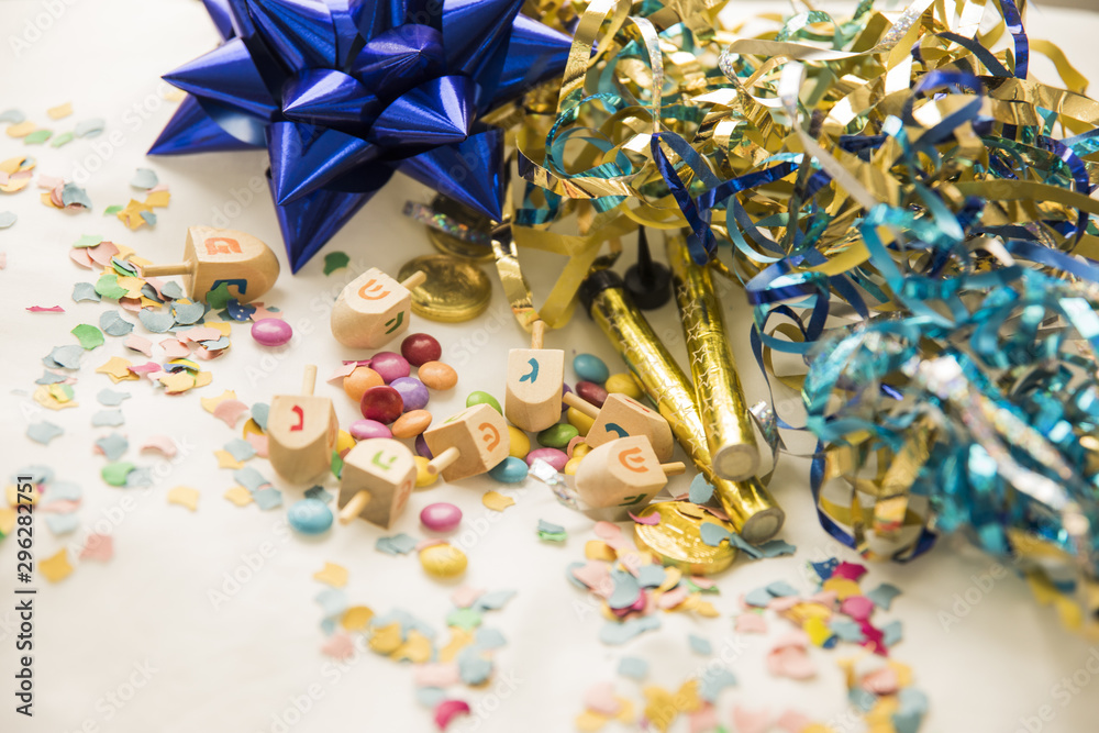 Dreidels and candies near confetti and tinsel