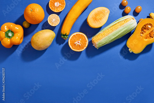 Fototapeta Naklejka Na Ścianę i Meble -  Collection of fresh yellow fruit and vegetables on the blue background