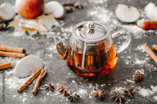 Black tea with spices in a teapot on the table photo