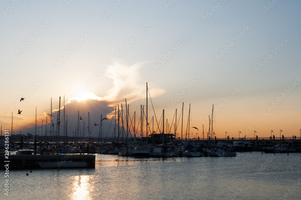 Wonderful romantic sunset at Adriatic sea in Gabicce, Italy. Boats and yachts in harbour under a colorful cloudy sky.