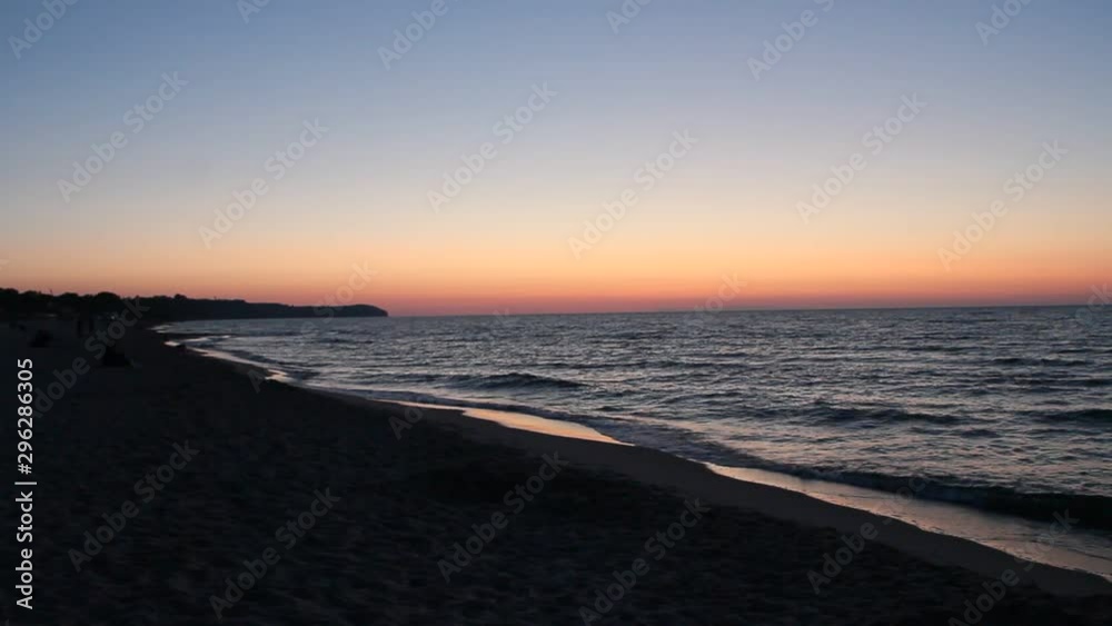Sunset on Baltic Sea. Baltic Sea coast during scarlet sunset. Waves on seashore in evening during sunset Sunset on Baltic Sea. Baltic Sea coast during scarlet sunset. Waves on seashore in evening during sunset