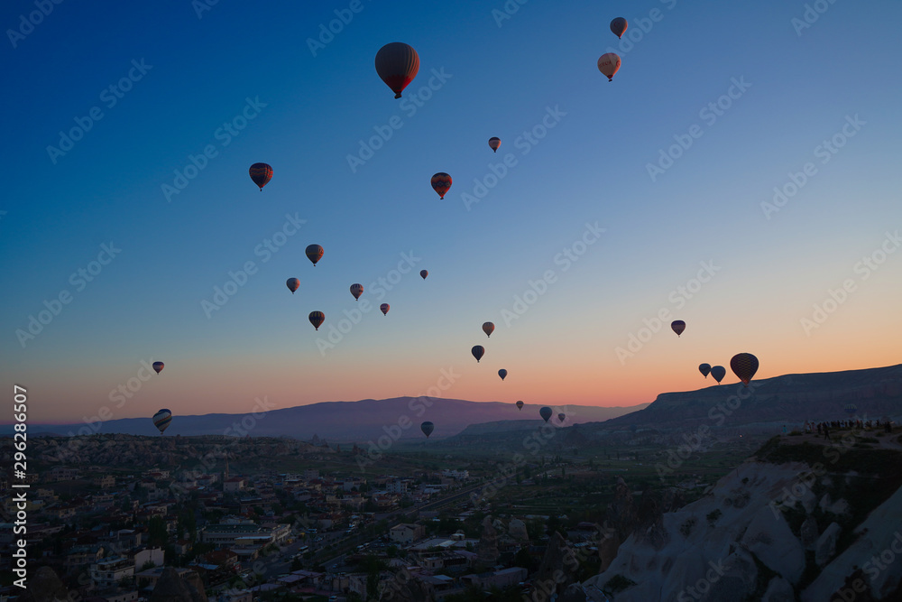 Sunrise panoramic view to Goreme city and flying balloons, Cappadocia, Turkey