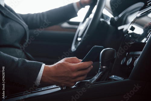 Don't use phone and drive. Modern businessman trying his new car in the automobile salon © standret
