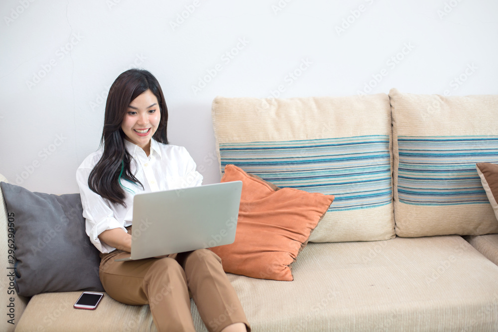 Young Asia women are using computers, books, phones, bills, cash and calculators. Online Inside her house Young Asia women are using computers, books, phones, bills, cash and calculators. Online Inside her house