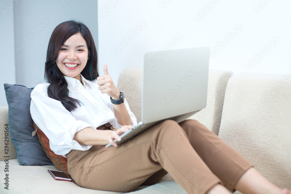 Young Asia women are using computers, books, phones, bills, cash and calculators. Online Inside her house Young Asia women are using computers, books, phones, bills, cash and calculators. Online Inside her house