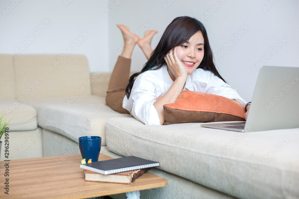 Young Asia women are using computers, books, phones, bills, cash and calculators. Online Inside her house Young Asia women are using computers, books, phones, bills, cash and calculators. Online Inside her house