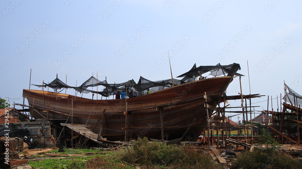 Timber shipbuilder working while working at a shipyard, Batang Indonesia, 14 October 2019 Timber shipbuilder working while working at a shipyard, Batang Indonesia, 14 October 2019