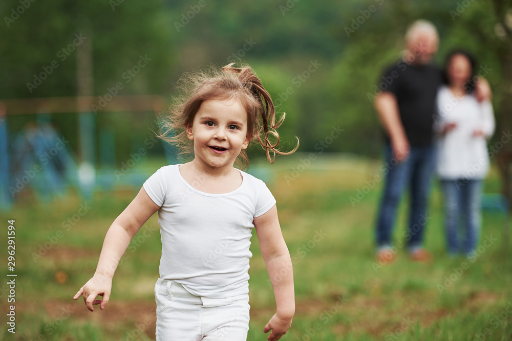 Front view. Grandmother and grandfather have fun outdoors with granddaughter. Painting conception Front view. Grandmother and grandfather have fun outdoors with granddaughter. Painting conception