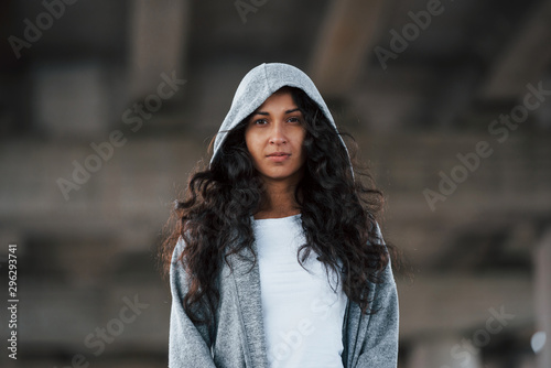 Portrait of beautiful young woman standing under the bridge outdoors © standret