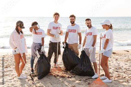 Photo of amazing volunteers teamwork cleaning beach from plastic together