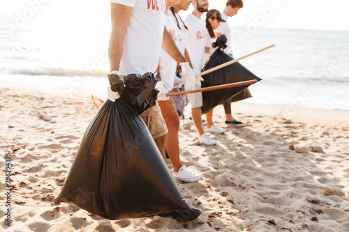 Photo of kind eco volunteers people cleaning beach from plastic trash
