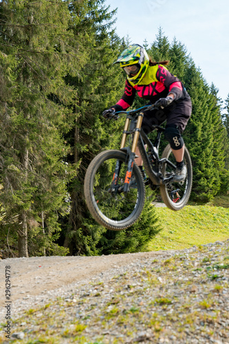 downhill mountain biker jumping high and riding hard in Lenzerheide in the Swiss Alps