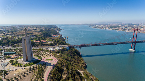 Aerial. Panorama from sky, a 25 de Abril Bridge and a statue of Jesus Christ. Lisbon.