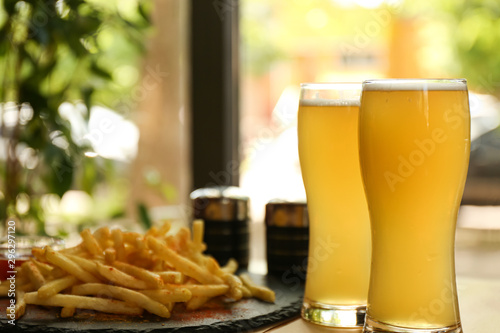 Delicious hot french fries and beer served on table