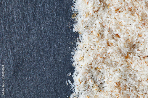 Psyllium (ispaghula) husk on black rustic background. Top view with copy space