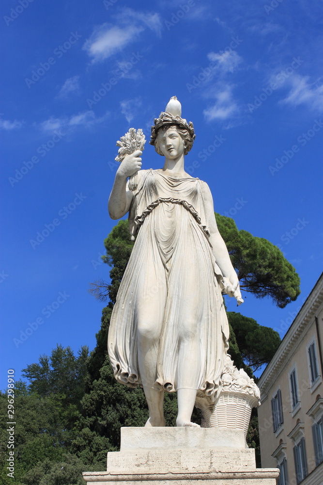 White stone statue of a woman with a bird sitting on her head