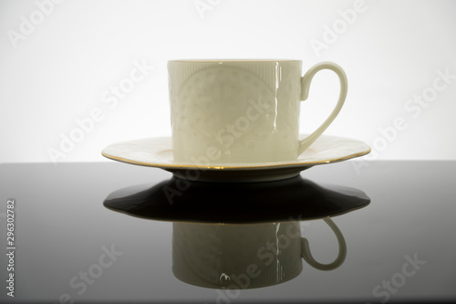 Fototapeta Naklejka Na Ścianę i Meble -  White coffee cup with plate on black table